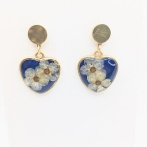 złote kolczyki sztyfty wiszące serca z białą tawułą na niebieskim tle