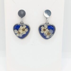 srebrne kolczyki sztyfty wiszące serca z białą tawułą na niebieskim tle