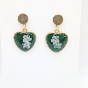 złote kolczyki sztyfty wiszące serca z białymi niezapominajkami na zielonym tle