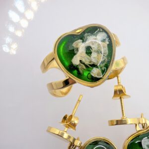 złoty duży pierścionek serce z niezapominajkami na zielonym tle