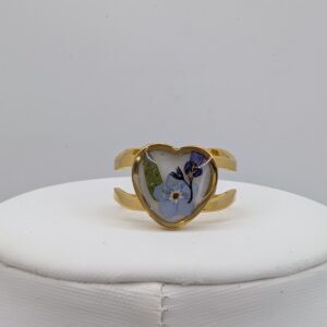 złoty duży pierścionek serce z niezapominajkami na białym tle