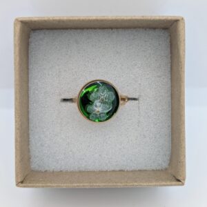 złoty pierścionek z białą niezapominajką na szmaragdowym tle