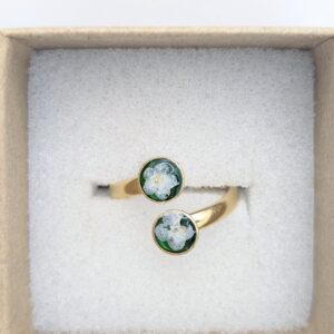 złoty pierścionek z białą niezapominajką na szmaragdowym tle z dwoma oczkami