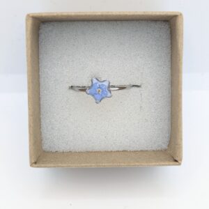 srebrny pierścionek gwiazdka z białą niezapominajką na białym tle