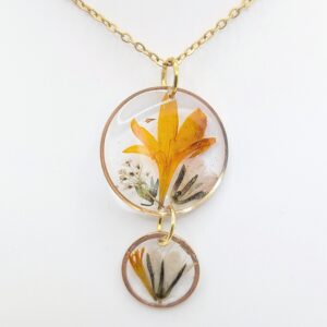 naszyjnik z dwóch złotych kółek z żółtymi płatkami i zielenią